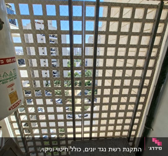רשת יונים מותקנת על מרפסת בבניין מגורים
